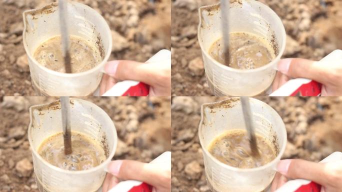土壤检测化验将土壤放到烧杯里搅拌泥水