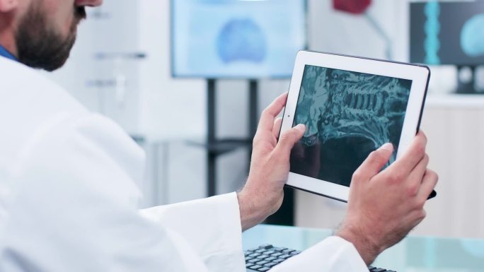 医生在平板电脑屏幕上分析 X光照片