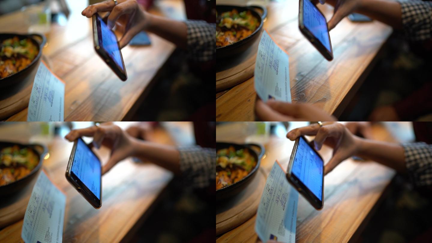 男子在餐厅用手机拍照支票