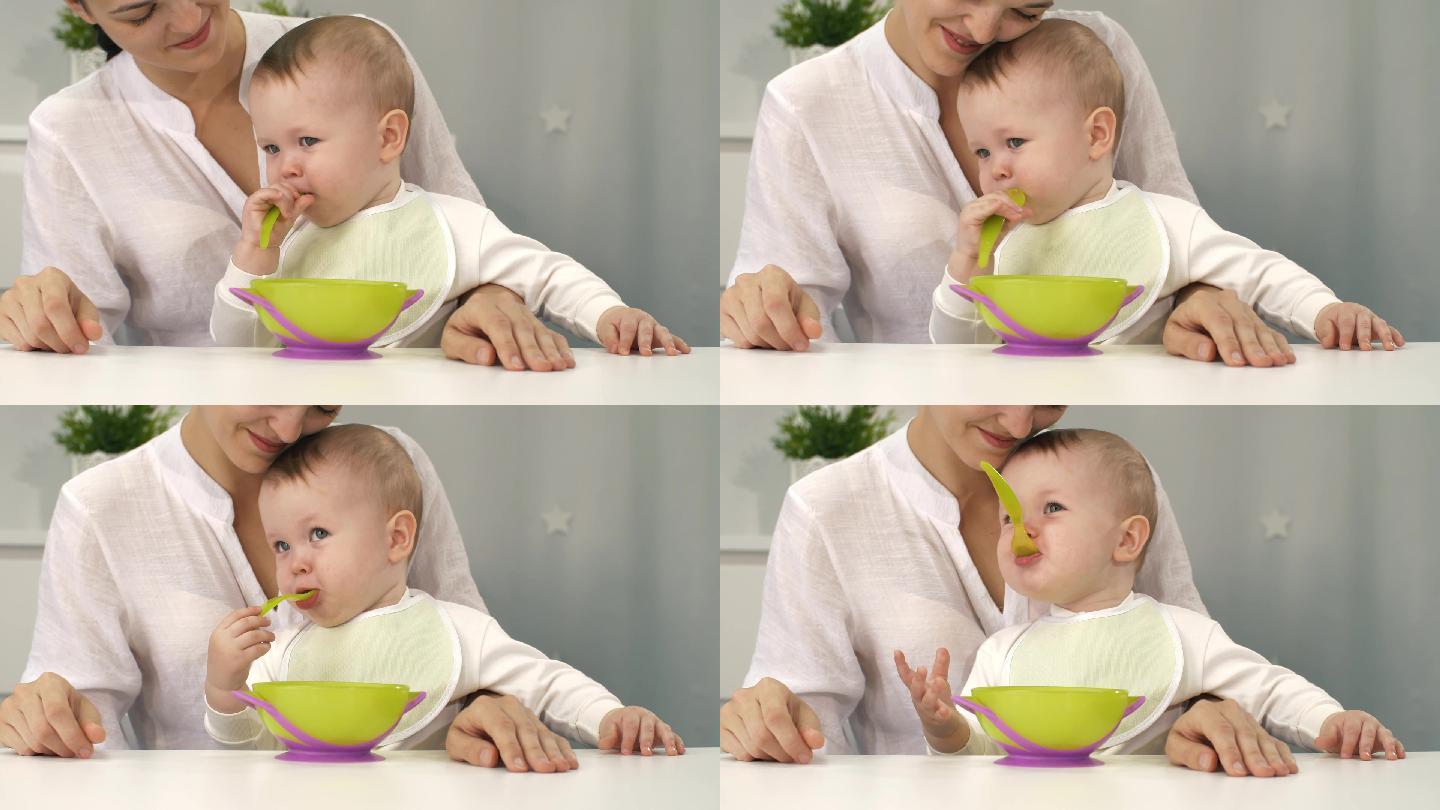 母亲帮助婴儿独自吃饭