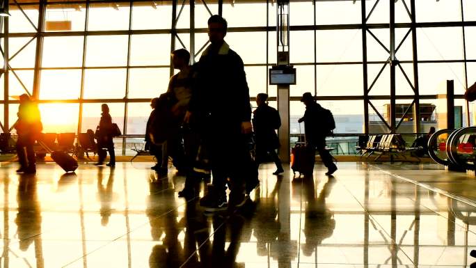 匆匆忙忙的人们带着行李走在机场里
