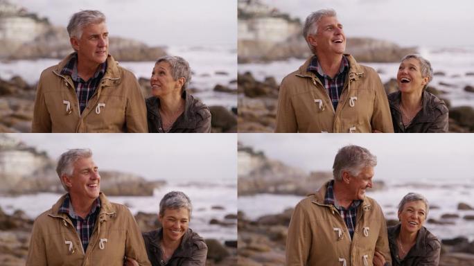一对快乐的夫妇在海滩边散步时相互拥抱