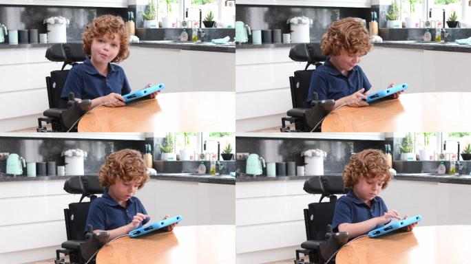 小男孩在家里轮椅上使用平板电脑