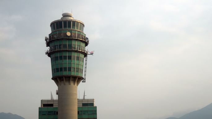 飞机飞过空中交通管制塔