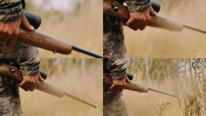 一个猎人手持步枪在芦苇丛中小心翼翼地行走
