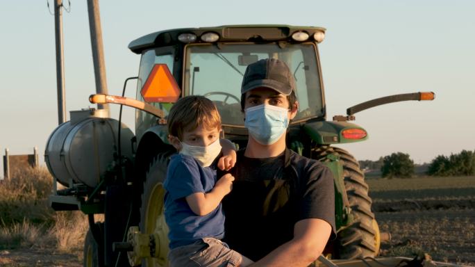带着口罩的年轻农民和他的儿子