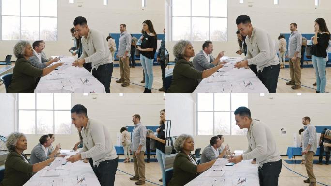 女性投票站志愿者向男性选民解释投票