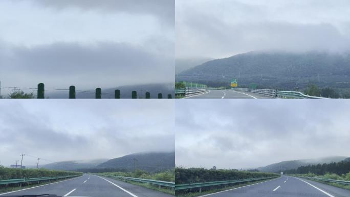 阴天驱车在山区高速山峰被乌云浓雾遮住
