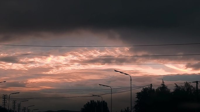 下班回家开车迎着夕阳行驶在大道上