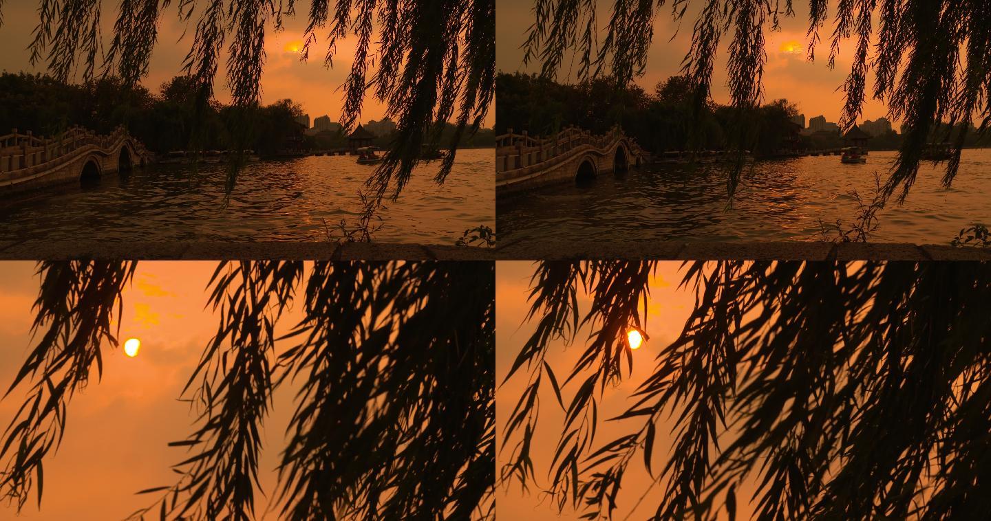 夕阳下的湖水和风中摇摆的柳树