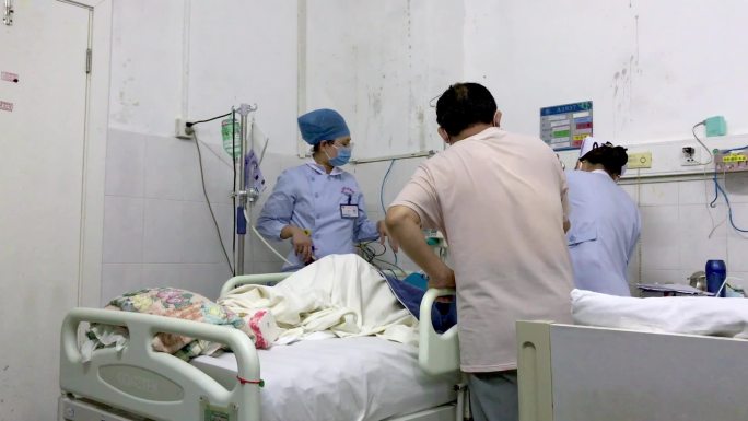 医护人员在病床前给病人做治疗场景