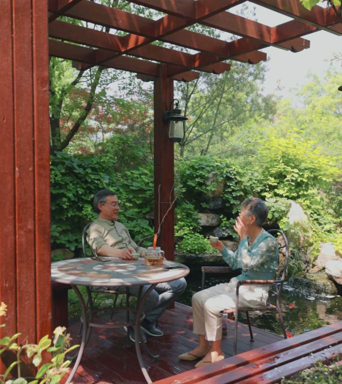 老年夫妇坐在院子里喝茶