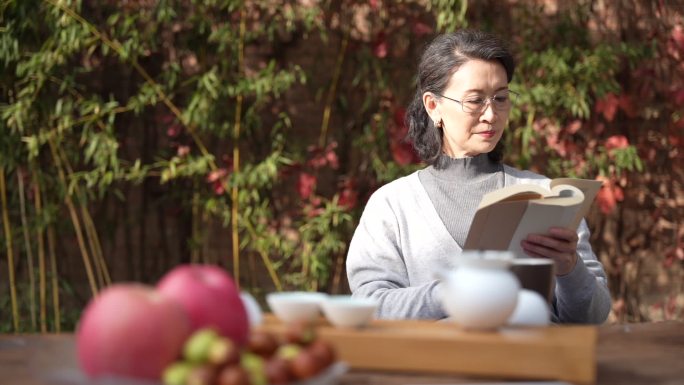 老年女人坐在院子里看书