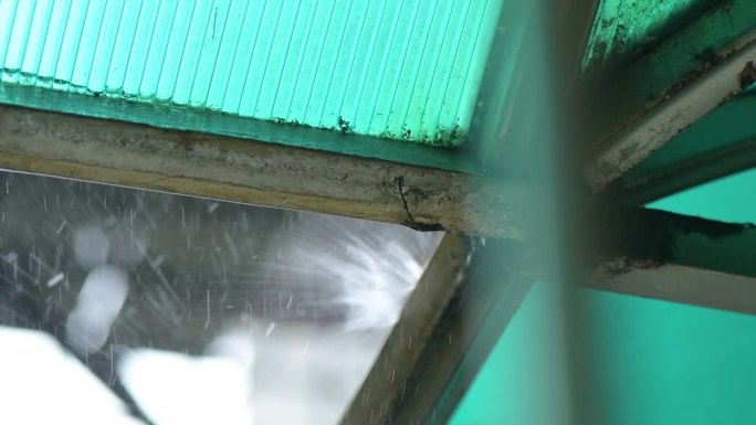 雨滴打在遮阳棚上溅起了水花