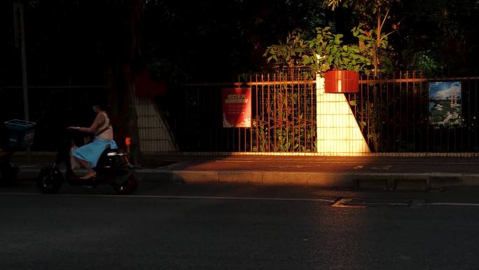 光影街道电动车上班下班马路车流夕阳光照