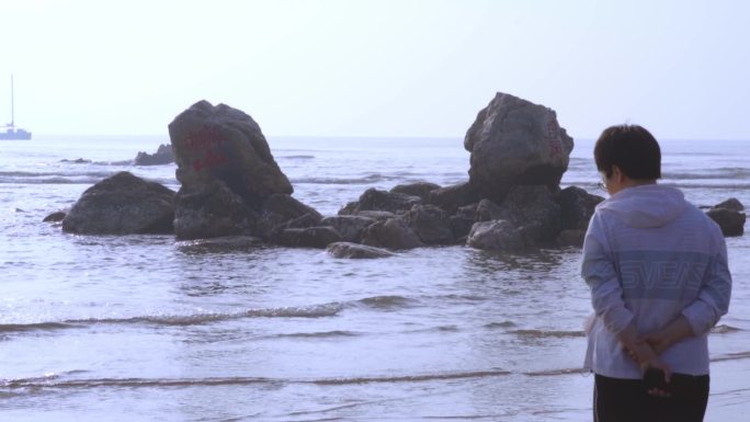 浅滩岩石浪花游客背影