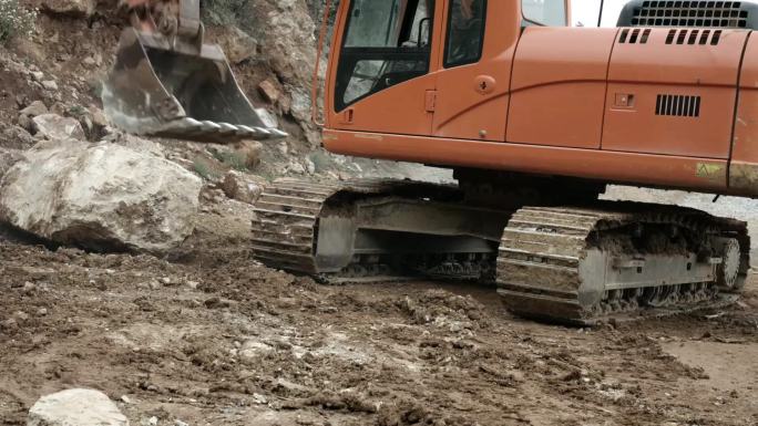 挖掘机师傅开挖机清理道路上的石头抢修救援