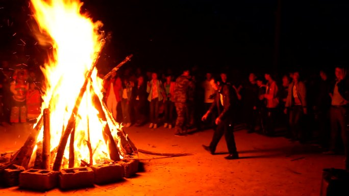 彝族村寨里的彝族火把节村民围绕篝火跳舞