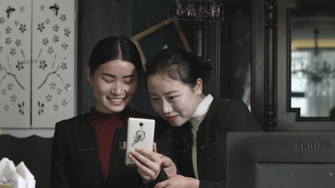 两女子非常开心看手机