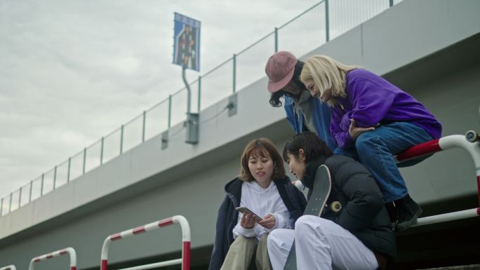 一群滑板运动员在智能手机上观看视频