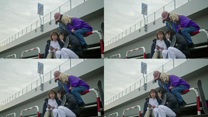 一群滑板运动员在智能手机上观看视频