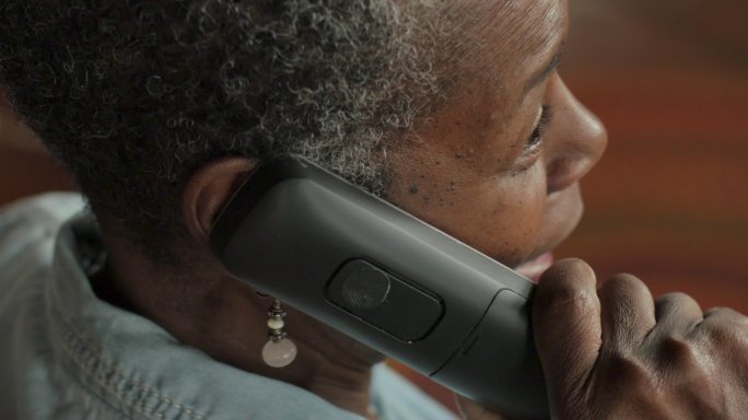 年长的妇女用无绳固定电话交谈