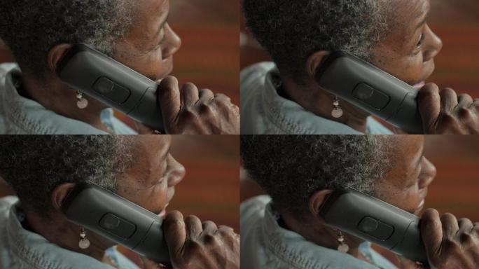 年长的妇女用无绳固定电话交谈