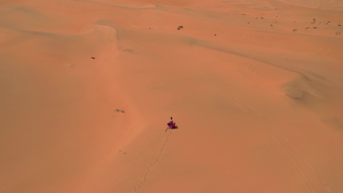 穿着敦煌服饰的美女在巴丹吉林沙漠上行走