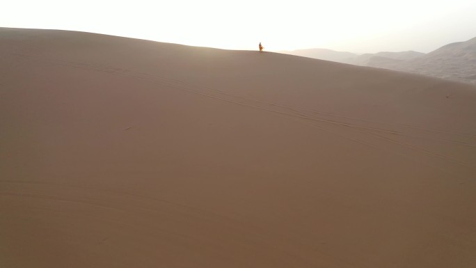 巴丹吉林沙漠日出时人物爬升航拍