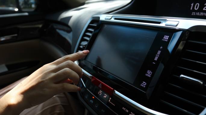 现代汽车中使用仪表板触摸屏的女性