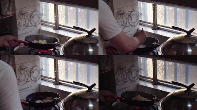 一位厨师在颠锅翻炒，炒菜炒莲藕
