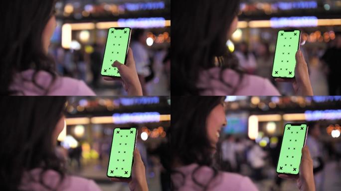 夜间使用绿色屏幕智能手机的女性