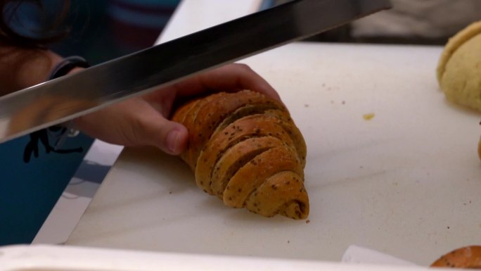 一位糕点师在切割一块法式可颂牛角包