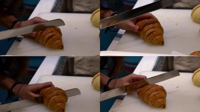 一位糕点师在切割一块法式可颂牛角包