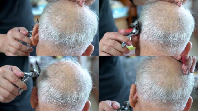 理发师正在给一位头发斑白的老人剪头发