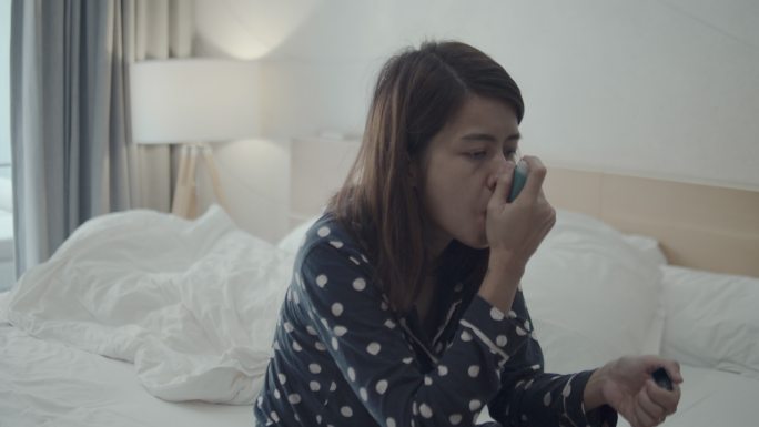 年轻女子使用哮喘吸入器