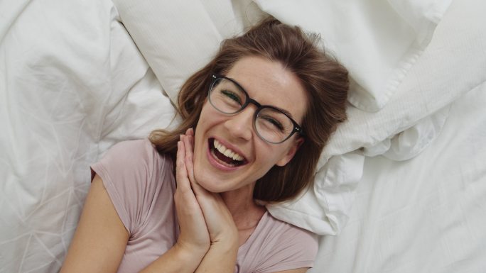 戴眼镜躺在床上的女人