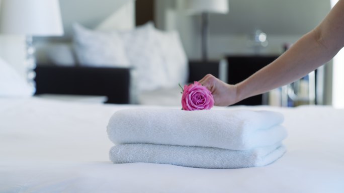 一名妇女将干净的毛巾放在床上