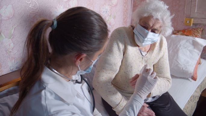 女医生在家里给一位老年妇女讲解药物