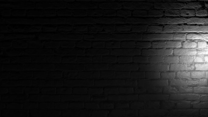 黑暗中手电筒光照亮砖墙