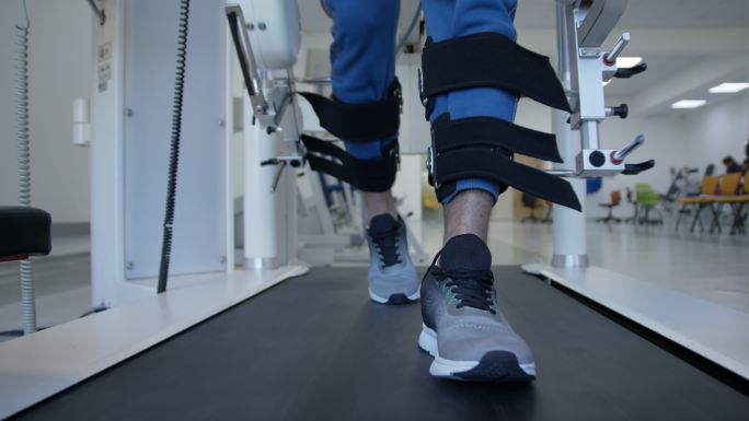 人类借助外骨骼机器在跑步机上行走