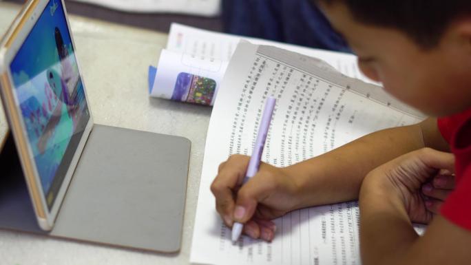 小学生假期在家用平板电脑上网课