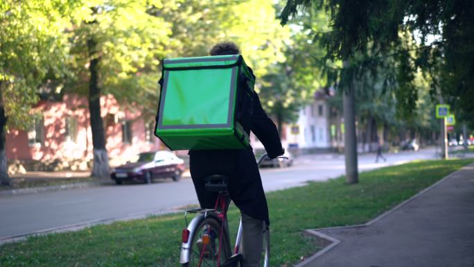 送货员骑着自行车在城市里运送食物