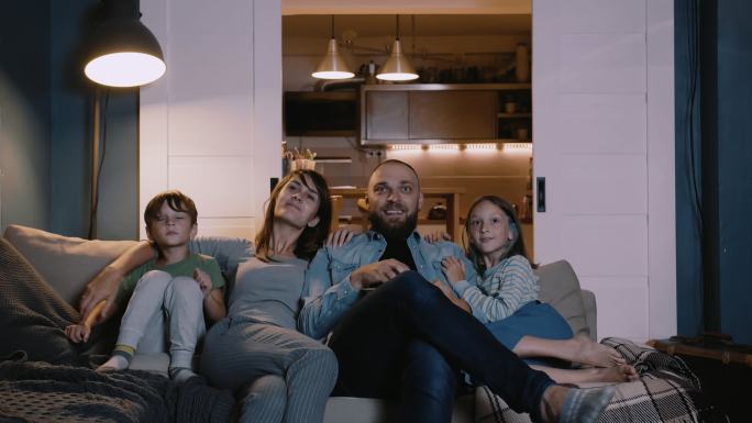 幸福的欧洲家庭聚在沙发上，在家看电视。