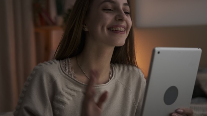 少女在夜间使用数字平板电脑进行视频聊天
