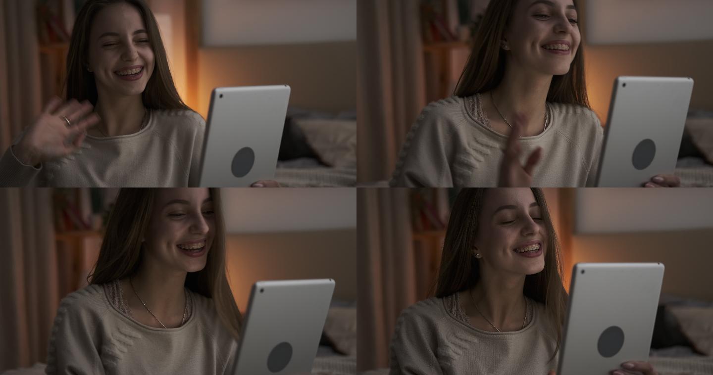 少女在夜间使用数字平板电脑进行视频聊天