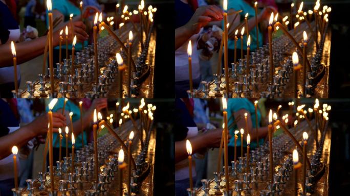 信徒在教堂特写镜头中点燃祈祷蜡烛