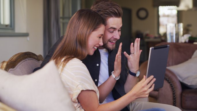 年轻夫妇用平板电脑宣布他们的婚姻