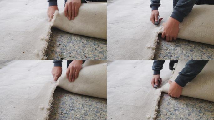 男子将旧地毯从地板上移开