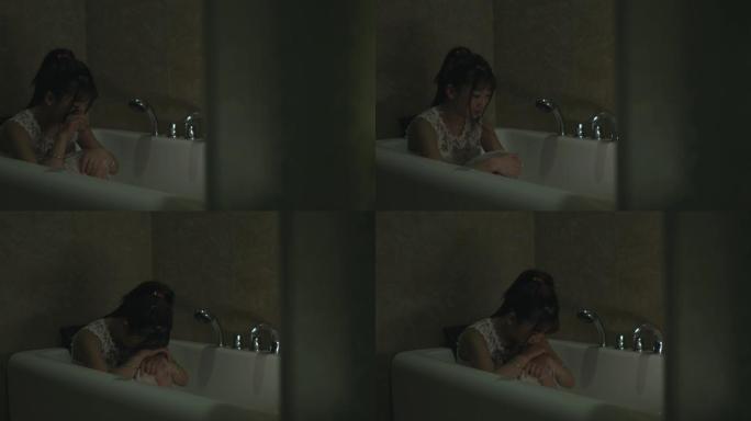女孩躲在浴缸里哭泣